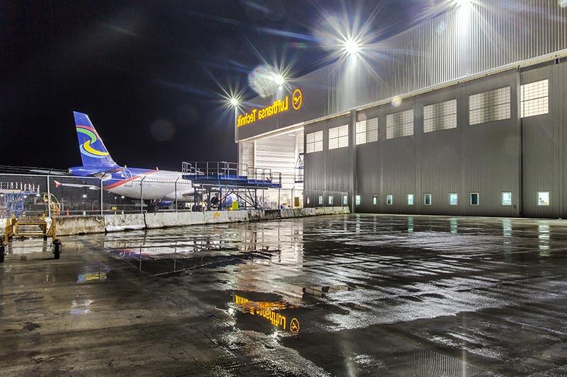 Exterior of 汉莎航空技术公司重型维修设施 at night. 飞机从后面进入机库.